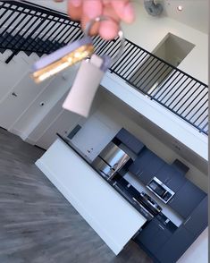 a person is holding something in their hand near the kitchen counter top and staircases