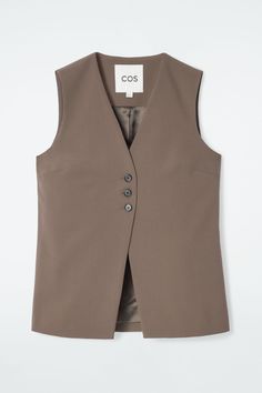 Modular suiting is central to the COS womenswear collection. Offered in an enduring steel-gray tone, this vest is crafted from RWS wool-blend twill and has an elongated silhouette. Style it with the coordinating pants. Regular fitButton closureA better alternative to conventional polyester, recycled polyester is made from pre‐ and post‐consumer waste  Shell: 55% Recycled polyester, 43% RWS Wool, 2% Elastane. Excluding trims / Dry clean Back length of size 6 is 25.70" / Model wears a size 6 Belted Cape, Gilet Long, Denim T Shirt, Tailored Blazer, Knee High Leather Boots, Short Shirts, Denim Pant, Long A Line, Jacket Dress