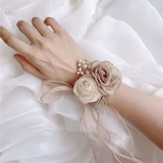 a close up of a person's hand wearing a wrist corsage