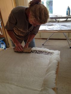 a woman is working on some kind of art project in her home studio, while she's making something out of an old mattress