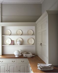 an image of a kitchen with white dishes on the shelves