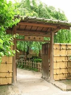 an entrance to a garden with bamboo fences