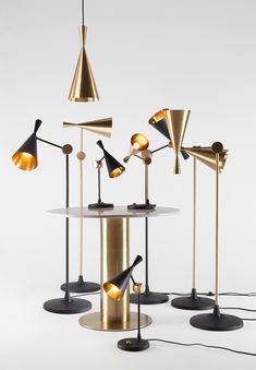 three lamps are sitting on top of a table with four different lights in front of them