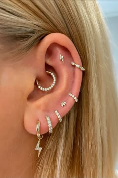 a woman's ear with three different types of piercings