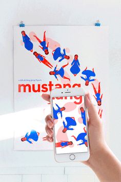 a person holding an iphone in front of a poster that reads mustar on it