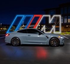 a white sports car parked in a parking lot at night with neon letters above it