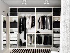 an open closet with clothes hanging on it