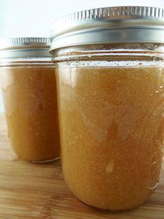 two jars filled with peanut butter sitting on top of a wooden table