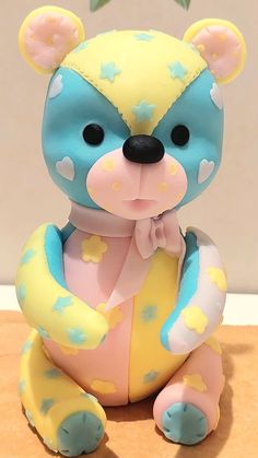 a blue and yellow teddy bear with stars on it's chest sitting on a table