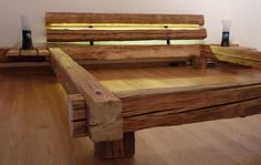 a wooden bed frame sitting on top of a hard wood floor next to a white wall