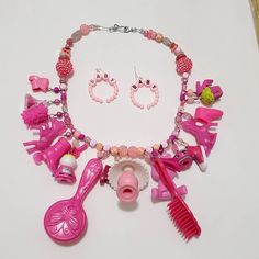 I collect toys as an adult, and I also have the desire to make art with them. This is a carefully curated collection of small toys that I've made into a chunky charm necklace. Comes with matching earrings.  Toys from vintage to modern are featured on here. The theme of this one is pink. This is a fairly heavy necklace because of all the goodies on it. Perfect if you love vintage and kawaii. Quirky Pink Jewelry Gift, Quirky Pink Jewelry As A Gift, Vintage Pink Charm Jewelry, Vintage Pink Jewelry With Charms, Pink Vintage Jewelry With Charms, Playful Pink Charm Necklaces For Jewelry Makers, Playful Pink Handmade Charm Necklaces, Playful Pink Handmade Charm Necklace, Playful Handmade Pink Charm Necklace