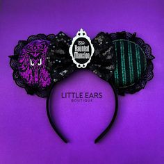 a purple and black minnie mouse ears headband with an evil face on it's side