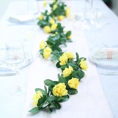 the table is decorated with yellow flowers and greenery