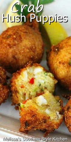 crab hush puppies on a plate with lemon wedges