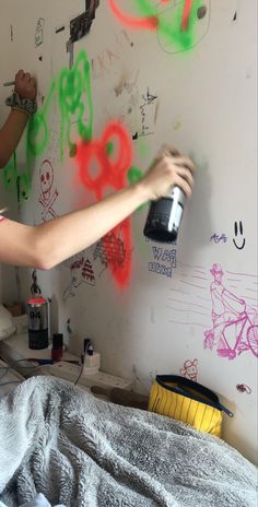 a person spray painting on a wall with graffiti