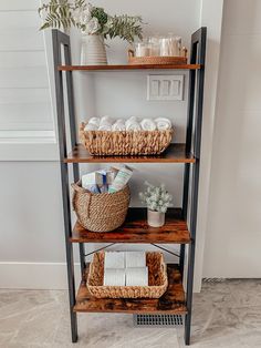 three shelves with baskets and towels on them