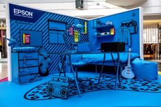 a room with blue walls and furniture on the floor in front of it is an advertisement for epson