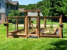 an outdoor garden area with wooden trelliss and plants in the center, surrounded by grass