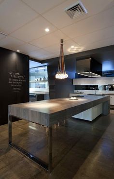 a modern kitchen with black walls and white cabinets, an island countertop and stainless steel appliances