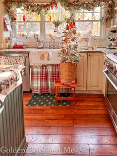 a kitchen decorated for christmas with wreaths on the window sill and garland hanging from the ceiling