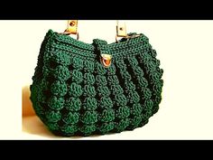 green crocheted purse with gold handles on white background