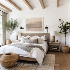 a bedroom with white walls and wood beams on the ceiling is decorated in neutral tones