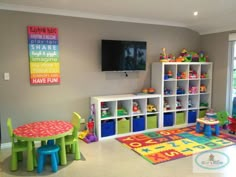 a playroom with toys and colorful rugs on the floor in front of a flat screen tv