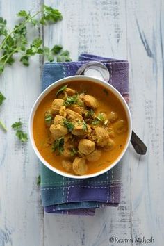 a white bowl filled with food on top of a blue napkin