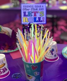 a purple table topped with cups filled with straws