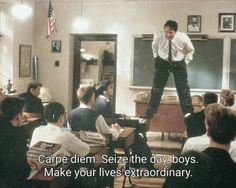 a man standing on top of a desk in a classroom