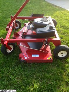 a red lawn mower sitting in the grass