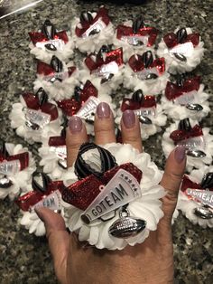 a woman's hand with red, white and black hair clips on it that have been placed in front of her