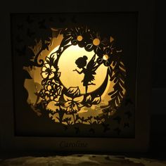 the shadow of a fairy on a paper cut in to a frame with an image of tinkerbell