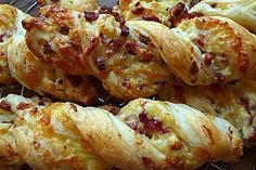 some breads that are sitting on a wire rack with cheese and bacon in them