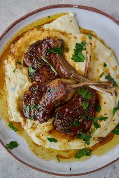 a white plate topped with meat covered in sauce and garnished with parsley