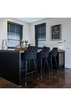 four black chairs are sitting at the bar in this modern style kitchen with marble flooring