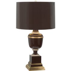 a table lamp with a black shade on it and a gold trim around the base