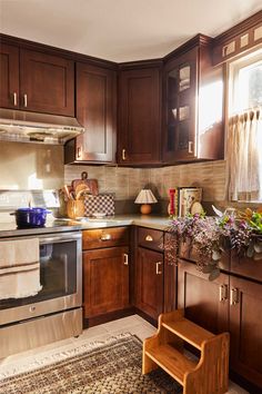 a kitchen with wooden cabinets and an area rug on the floor in front of the stove