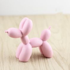 a pink balloon dog sitting on top of a wooden table