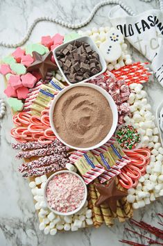 a platter filled with candy, marshmallows, and other candies