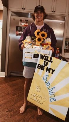 a woman holding a sign that says will you be my sunflower?