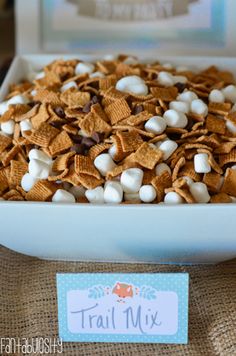 a white bowl filled with cereal and marshmallows on top of a table