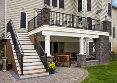 a patio with stairs leading up to the second floor and an outdoor living area on the other side