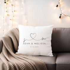 a white pillow sitting on top of a couch next to a wall with christmas lights