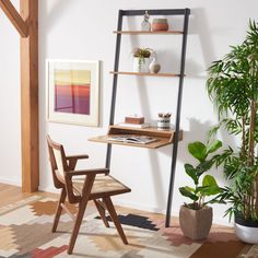 a wooden chair sitting in front of a desk next to a potted plant and bookshelf