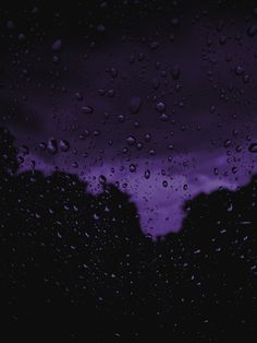 rain drops on the window with purple clouds in the background