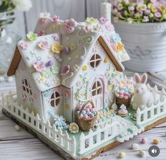 a small white house decorated with flowers and eggs