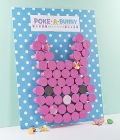 a pink bunny made out of circles on top of a blue and white polka dot paper