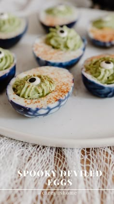 several small cupcakes with green toppings on a white platter and the words spooky deviled eggs above them