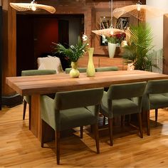 a wooden table with green chairs around it